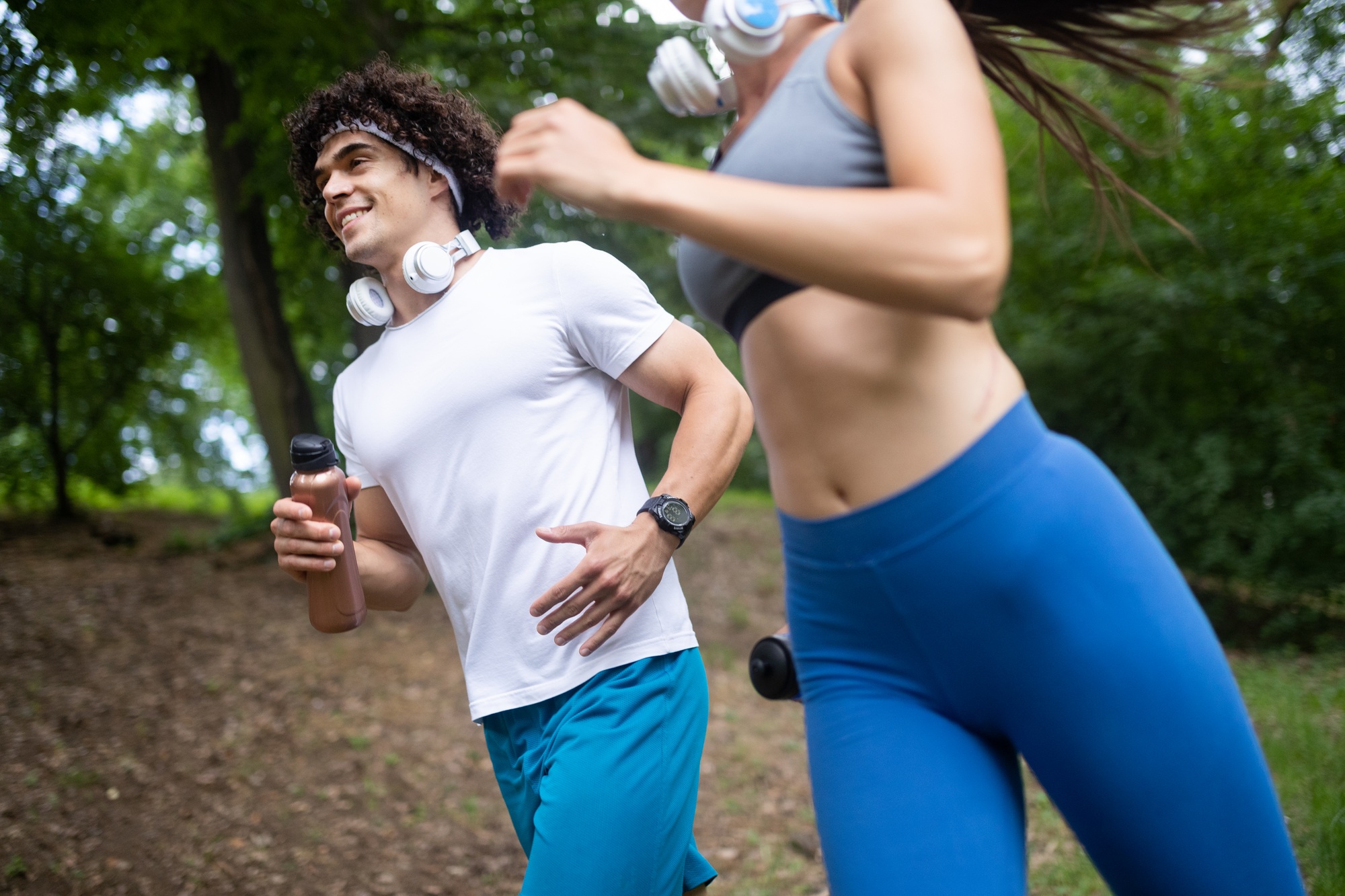Happy young woman doing excercise outdoor in a park, jogging