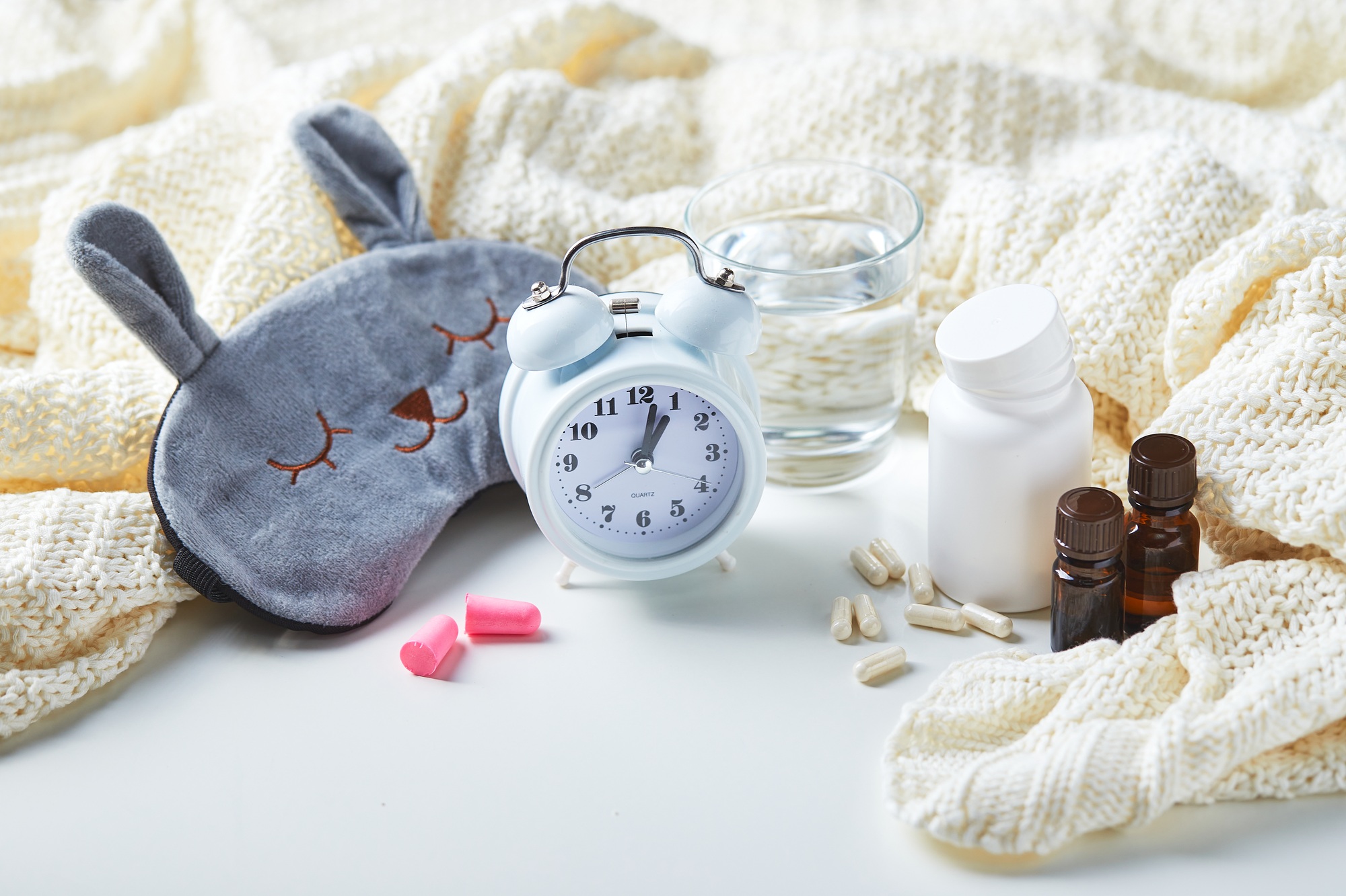 Sleeping mask, alarm clock, earplugs and pills. Healthy night sleep creative concept.