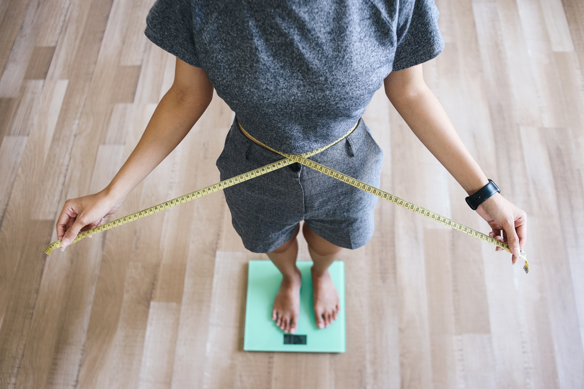 Slim Girl Measure Waist and Weighing Body